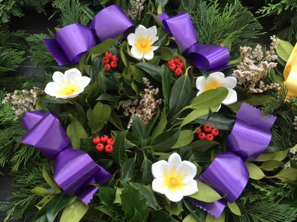 fresh holly wreath berries white yellow flowers purple ribbon